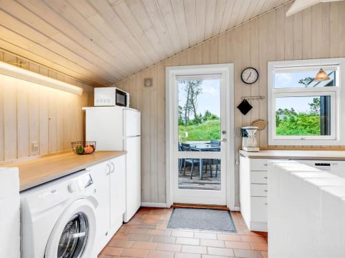 a kitchen with a washer and dryer at Holiday Home Adrienne - 240m from the sea by Interhome in Hirtshals