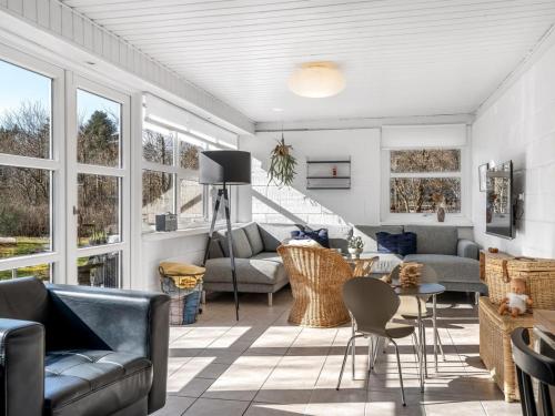 a living room with couches and tables and windows at Holiday Home Karmen - 250m to the fjord by Interhome in Sønder Ydby