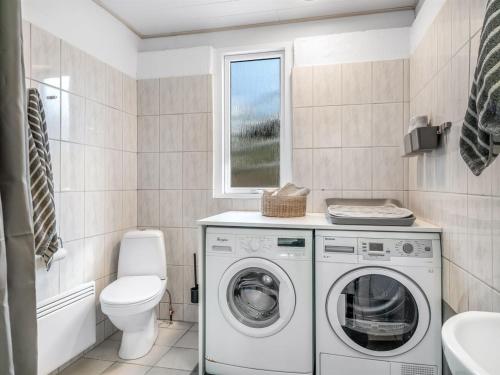 a bathroom with a washing machine and a toilet at Holiday Home Karmen - 250m to the fjord by Interhome in Sønder Ydby