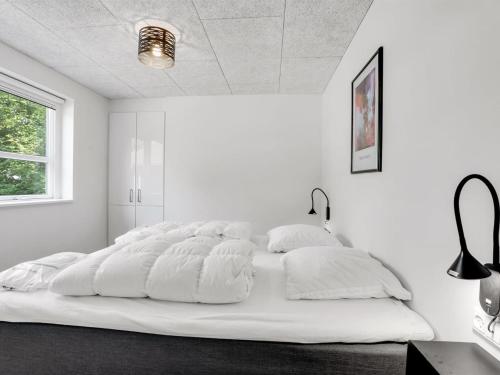 a large white bed in a white room at Holiday Home Patrice - 300m from the sea by Interhome in Strøby