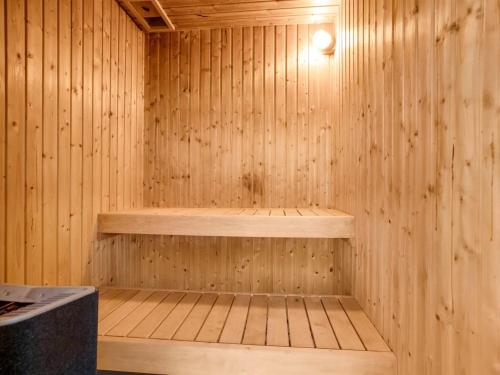 a wooden sauna with a wooden bench in it at Holiday Home Patrice - 300m from the sea by Interhome in Strøby