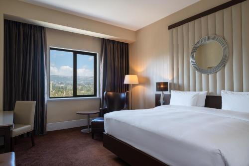 a hotel room with a large bed and a mirror at Radisson Blu Hotel, Addis Ababa in Addis Ababa
