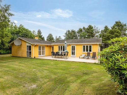 a yellow house with a yard at Holiday Home Ahnandia - 200m from the sea by Interhome in Jerup