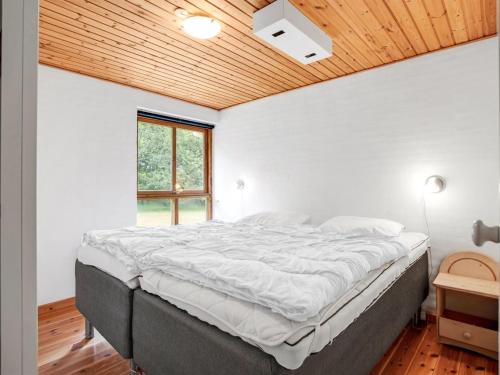 a large bed in a bedroom with a wooden ceiling at Holiday Home Ahnandia - 200m from the sea by Interhome in Jerup