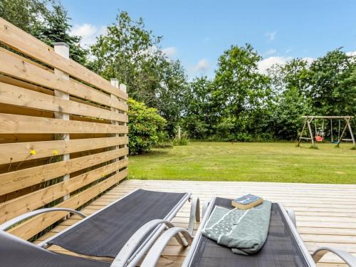 a table and chairs on a deck with a playground at Holiday Home Ahnandia - 200m from the sea by Interhome in Jerup