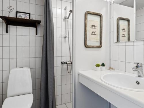 ルーケベングにあるApartment Reimer - 10m from the sea by Interhomeのトイレと洗面台を備えた白いバスルーム