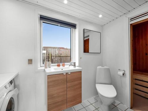 a bathroom with a toilet and a sink and a window at Holiday Home Darja - 300m from the sea by Interhome in Thyborøn