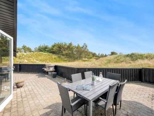 a wooden table and chairs on a patio at Holiday Home Emin - 700m from the sea by Interhome in Vejers Strand