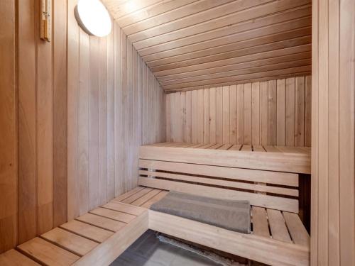 a small wooden sauna with a bench in it at Holiday Home Emin - 700m from the sea by Interhome in Vejers Strand