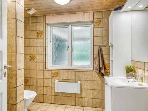 a bathroom with a toilet sink and a window at Holiday Home Lyra - 500m to the fjord by Interhome in Øsløs