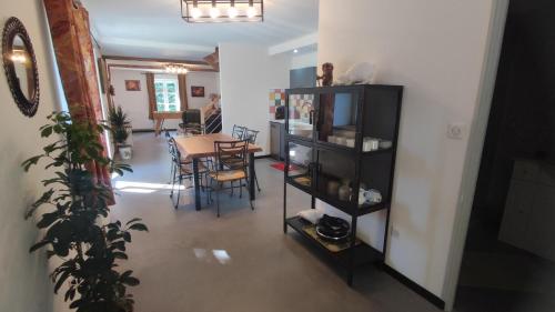 Una sala de estar con una mesa y un comedor. en La goutelle, en Neufmanil