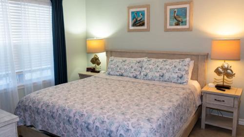 a bedroom with a bed with two night stands and two lamps at Surfside II #109 home in Coffeyville