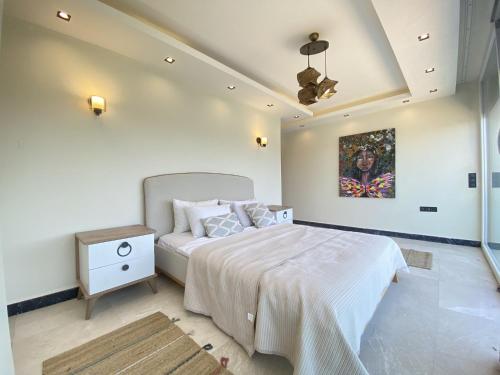 a bedroom with a bed and a painting on the wall at Luxury Villa w Private Pool Panoramic View in Bogazici