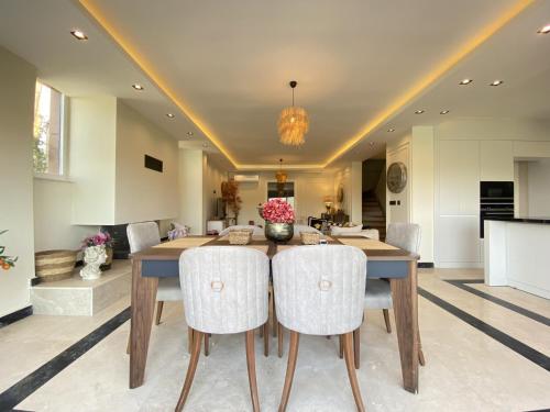 a dining room with a wooden table and white chairs at Luxury Villa w Private Pool Panoramic View in Bogazici