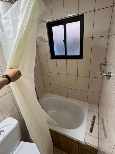 a bathroom with a bath tub and a window at Pucón, casa en parcela in Pucón