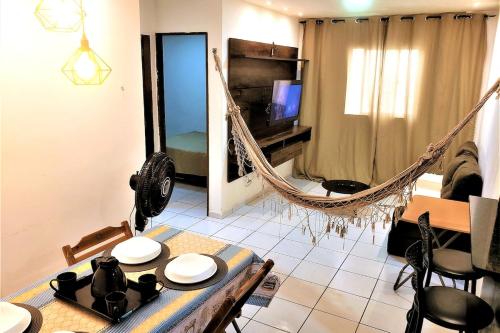 a living room with a hammock and a table and chairs at Dona Lindu 3 - Bodocongo (Campina Grande-PB) in Campina Grande