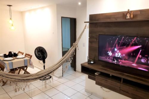 a living room with a large tv and a hammock at Dona Lindu 3 - Bodocongo (Campina Grande-PB) in Campina Grande