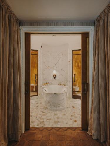 a large bathroom with a tub in the middle at Grand Hotel Timeo, A Belmond Hotel, Taormina in Taormina