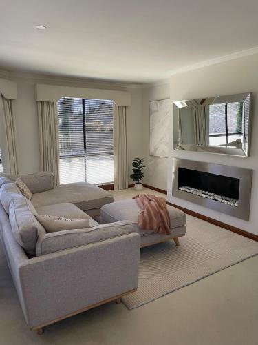 a living room with two couches and a fireplace at Blackstone Lakeside 4 Bedrooms 2 Bathrooms in Hadspen