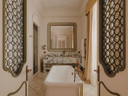 a bathroom with a white tub and a sink at Grand Hotel Timeo, A Belmond Hotel, Taormina in Taormina