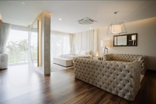 a living room with a couch and a bed at Palm Villa - Award Winning Modern Luxury & Exclusive Villa in Chiang Mai