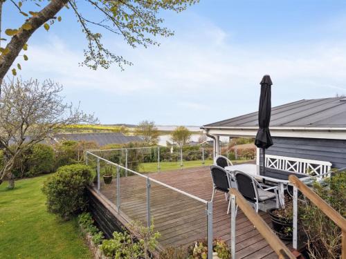 a deck with chairs and an umbrella on a house at Holiday Home Annabeth - 300m to the fjord by Interhome in Løgstrup