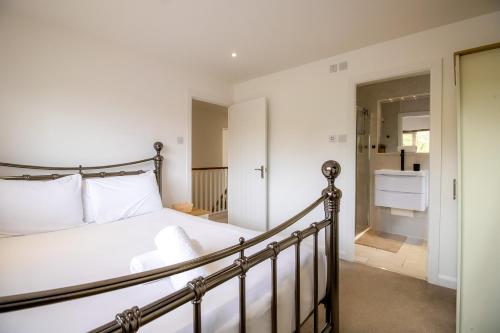 a bedroom with a bed and a bathroom at Beautiful and Cosy 4-bed Home in Milton Keynes by Renzo, Driveway, Close to M1 in Milton Keynes