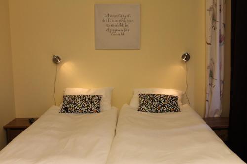 a bed with two pillows on it in a room at Stationshusets Hotell och Café in Köping