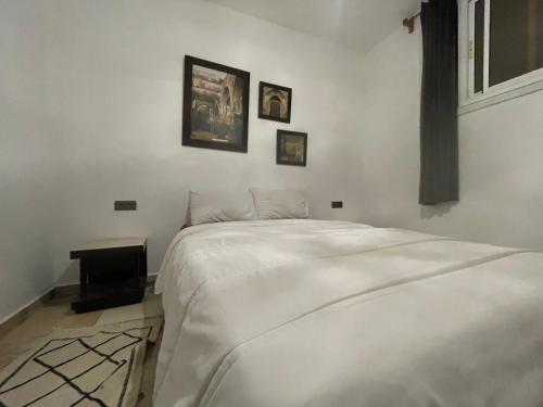 a bedroom with a bed and two pictures on the wall at Eco Bay Surf Camp in Aourir