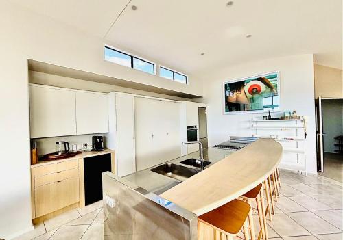 a kitchen with a sink and a counter top at Supreme on Marine - Beachfront! in Mount Maunganui