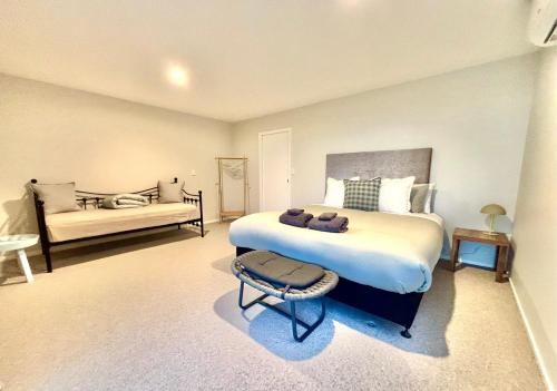 a bedroom with a large bed and a couch at Supreme on Marine - Beachfront! in Mount Maunganui