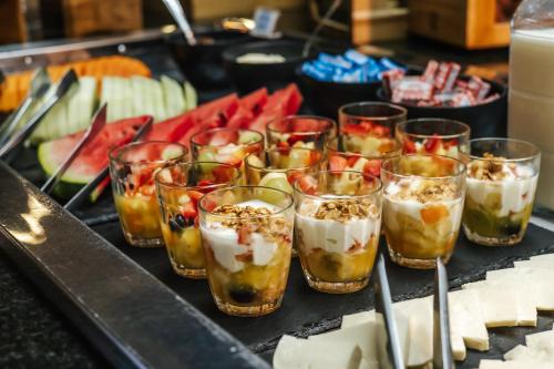 a bunch of glasses filled with food on a table at Aéra São José Floripa in São José