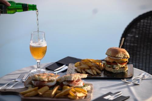 a table with a sandwich and chips and a glass of beer at Karavia Lux Inn in Afissos