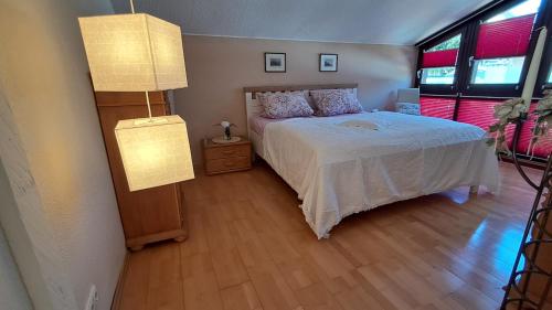 a bedroom with a bed and two windows at ChristRose in Trechtingshausen