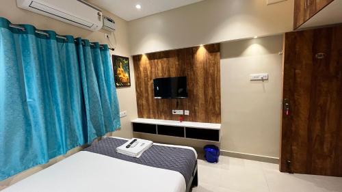 a hospital room with a bed and a tv at Greenapple Residency in Chennai