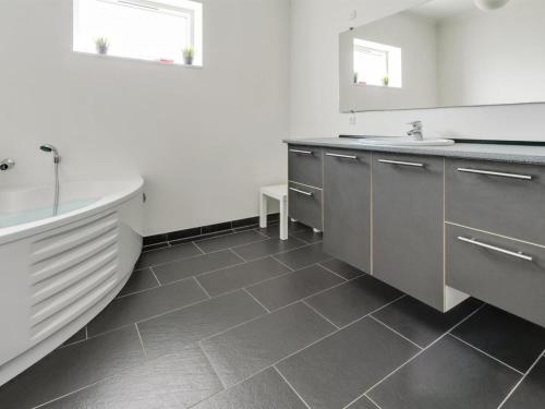 a bathroom with a bath tub and a sink at Holiday Home Edda - 400m from the sea by Interhome in Hals