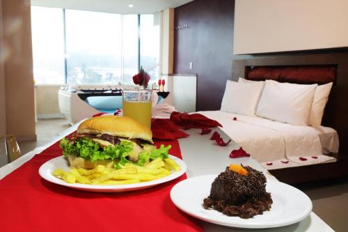 a table with a sandwich and fries and a glass of beer at Emirates Hotel & Suites in Santana do Livramento
