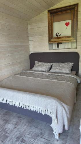 a bed in a room with a picture on the wall at Olly House in Glebovka