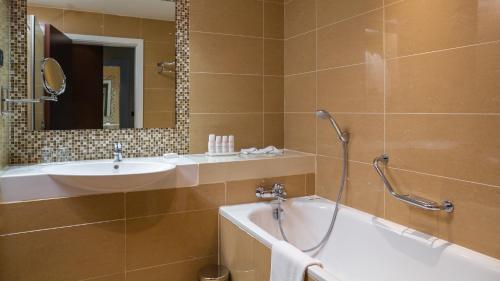 a bathroom with a tub and a sink and a shower at Radisson Blu Hotel, Addis Ababa in Addis Ababa
