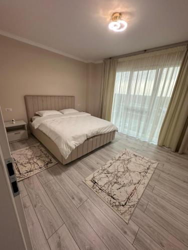 a bedroom with a bed and a large window at Apartament Calea Bucovinei in Rădăuţi