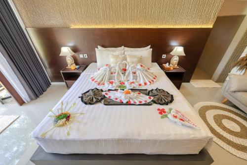 a large white bed with a tray of food on it at Kelingking Tropical in batumadeg