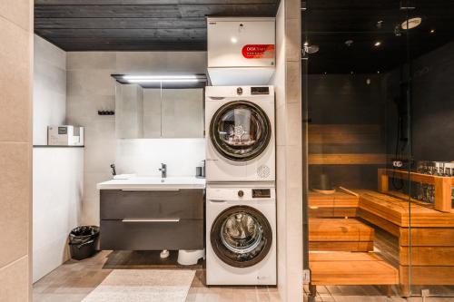 een keuken met een wasmachine en een wastafel bij Levi Cranberry C 13 ski-in ski-out Visit Levi in Levi