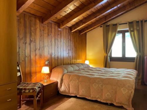 een slaapkamer met een groot bed en een raam bij Rifugio romantico per due in Pinzolo