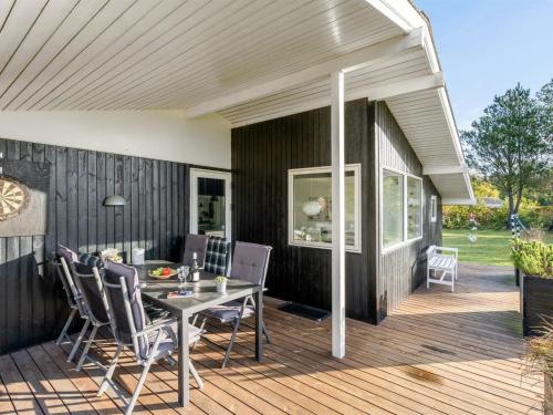 a patio with a table and chairs on a deck at Holiday Home Rosmarie - 600m from the sea by Interhome in Hals