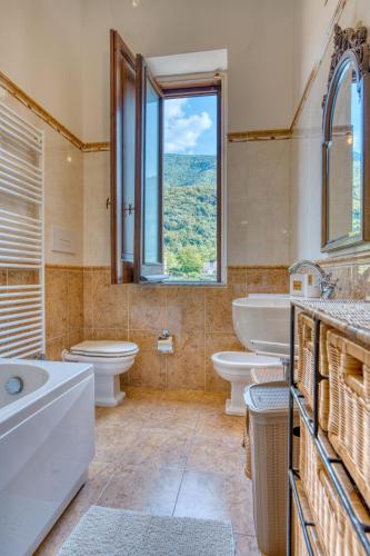 a bathroom with two sinks and two toilets and a window at Villa Desiderio Baronessa Apartment vista Vesuvio Pompei in Angri