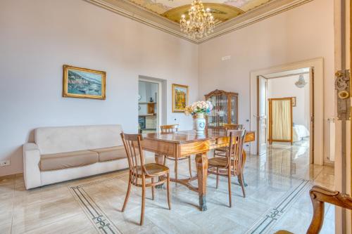 Un comedor con una mesa y sillas y un sofá. en La Baronessa Apartment near Pompei & Amalfi Coast, en Angri
