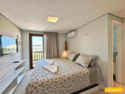 a bedroom with a bed and a large window at Pier 18 - Flecheiras in Flecheiras