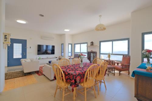a dining room and living room with a table and chairs at אלגריה - ווילה מהממת עם 4 חדרי שינה ונוף משגע בכמון in Kammon