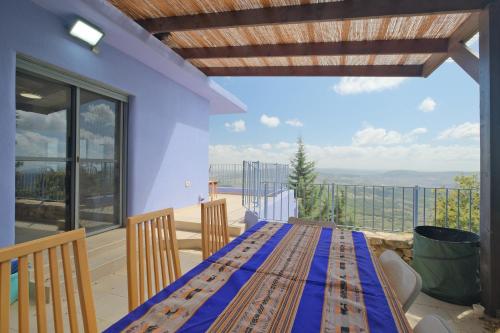 a blue table on a balcony with a view at אלגריה - ווילה מהממת עם 4 חדרי שינה ונוף משגע בכמון in Kammon