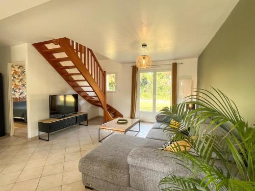 a living room with a couch and a staircase at Maison Belle Étoile à 5 min de la plage in Les Moitiers-dʼAllonne
